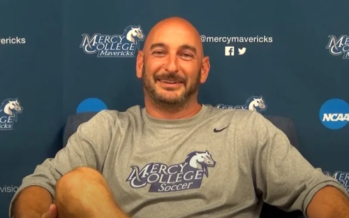Mercy College Soccer Coach Interview Smiling man in a Mercy College Soccer sweatshirt during a video interview with a Mavericks backdrop