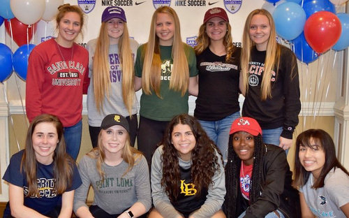 College Signing Group Photo Ten young women pose in college apparel with balloons at a soccer signing event.