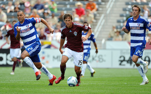 MLS Match Dribble Colorado Rapids player in burgundy dribbles past two FC Dallas defenders during an MLS match.