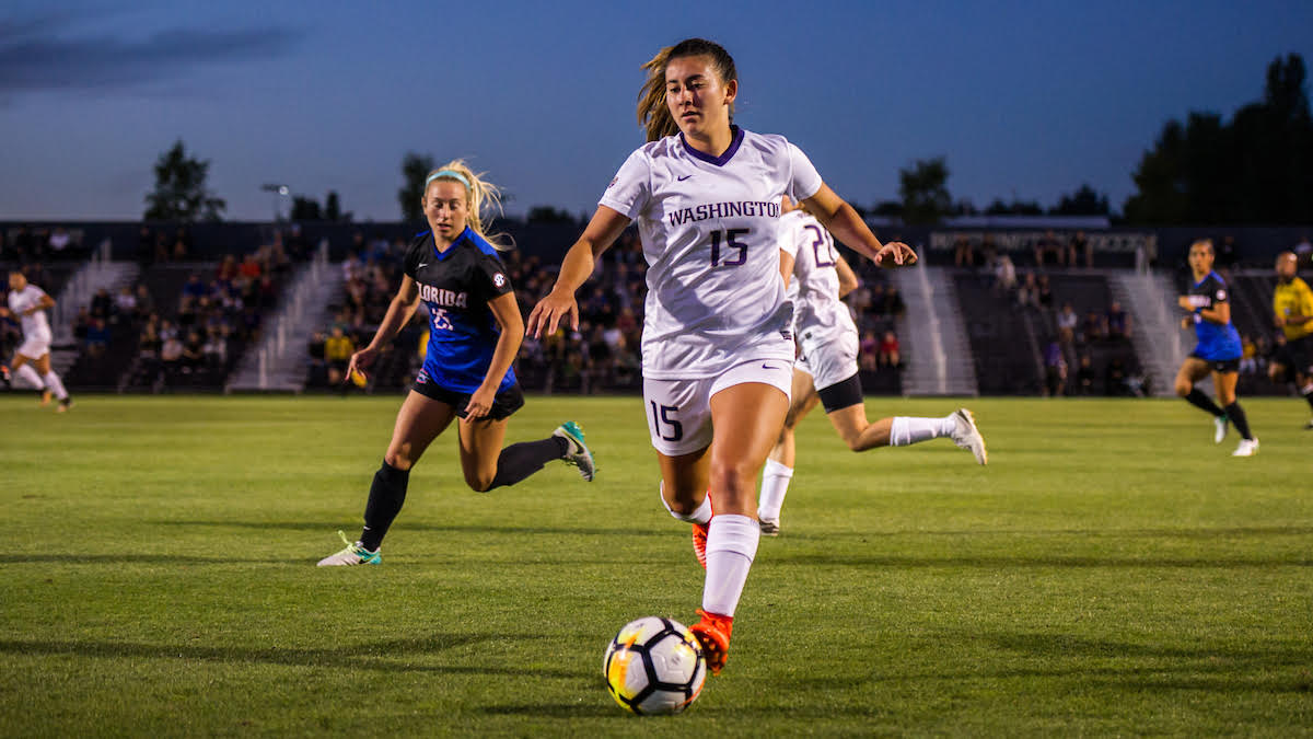 College Player At Night Match Washington women's player number 15 dribbling under lights during a night college soccer match
