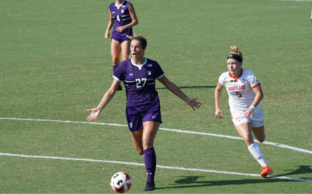 College Women Competing For Ball Northwestern player number 27 controlling the ball chased by a Maryland player number 5 during a college match