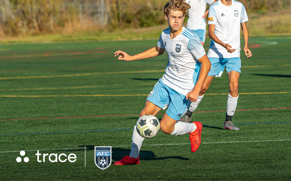 AFC Academy Partnership Graphic Boy in a white and light blue kit dribbling the ball, with Trace and AFC Academy logos along the bottom