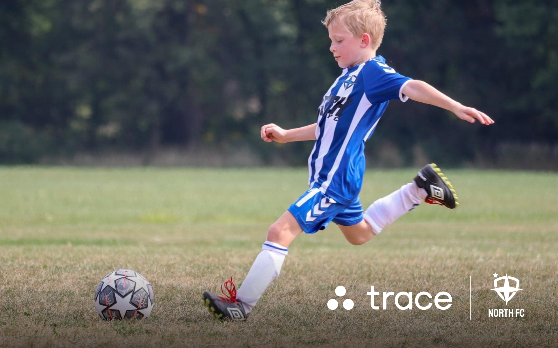 Boy Kicking Soccer Ball Young boy in a blue-striped kit kicking a soccer ball, with Trace and North FC logos