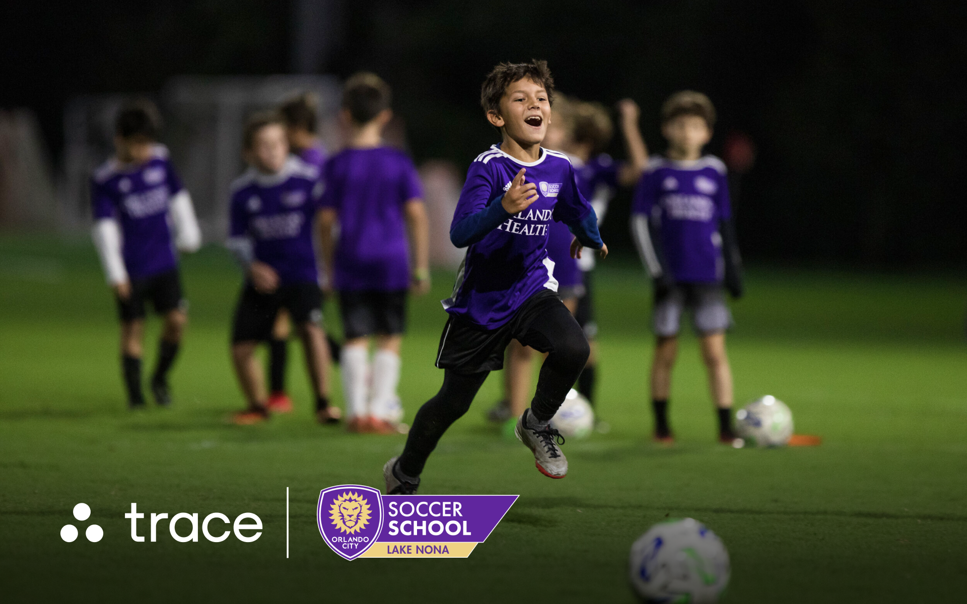 Boy in purple Orlando City jersey sprinting and smiling during night practice, with Trace and Orlando City logos.